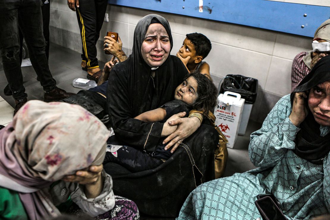Kobiety i dzieci oczekują na leczenie w szpitalu Al-Shifa we wtorek wieczorem.