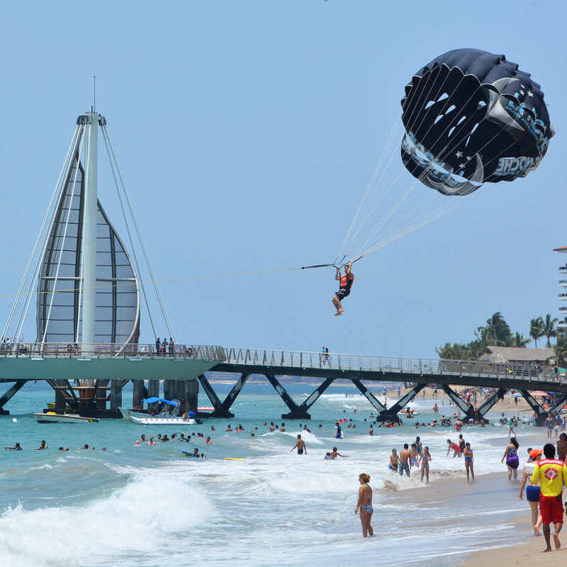 Ruchliwa piaszczysta plaża w Puerto Vallarta, w pobliżu promenady Malecon, Jalisco, Meksyk