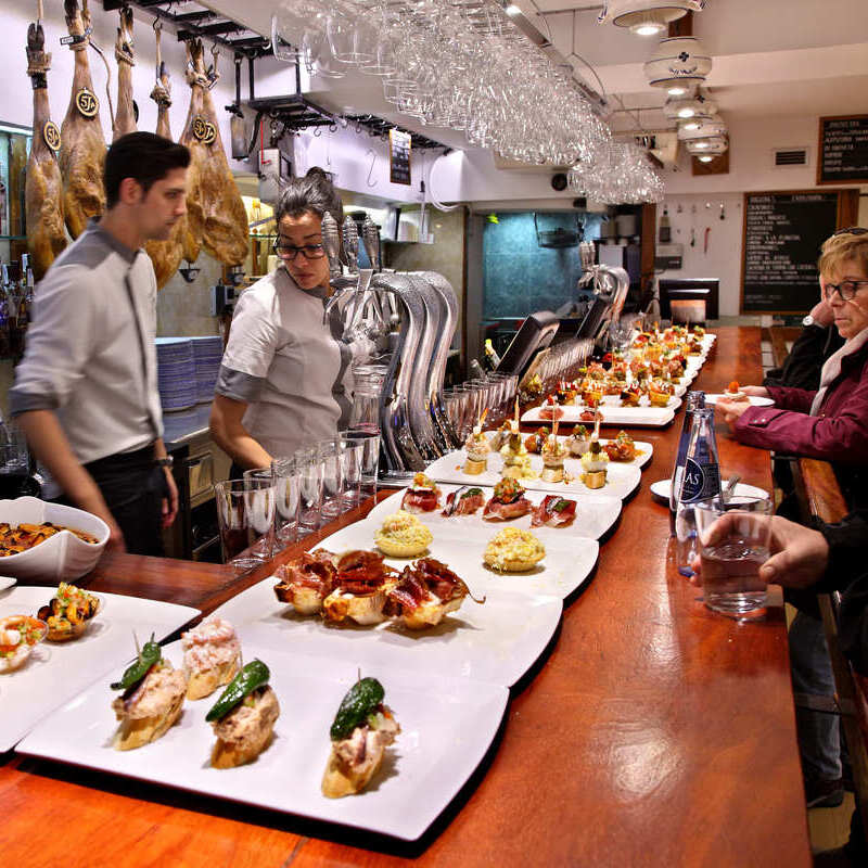Klienci obsługiwani w barze Pintxo w Donostii, San Sebastian, Hiszpania