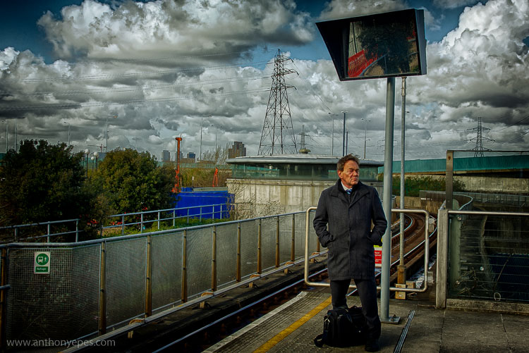 mężczyzna stojący przy linii tramwajowej, fotografia portretowa uliczna