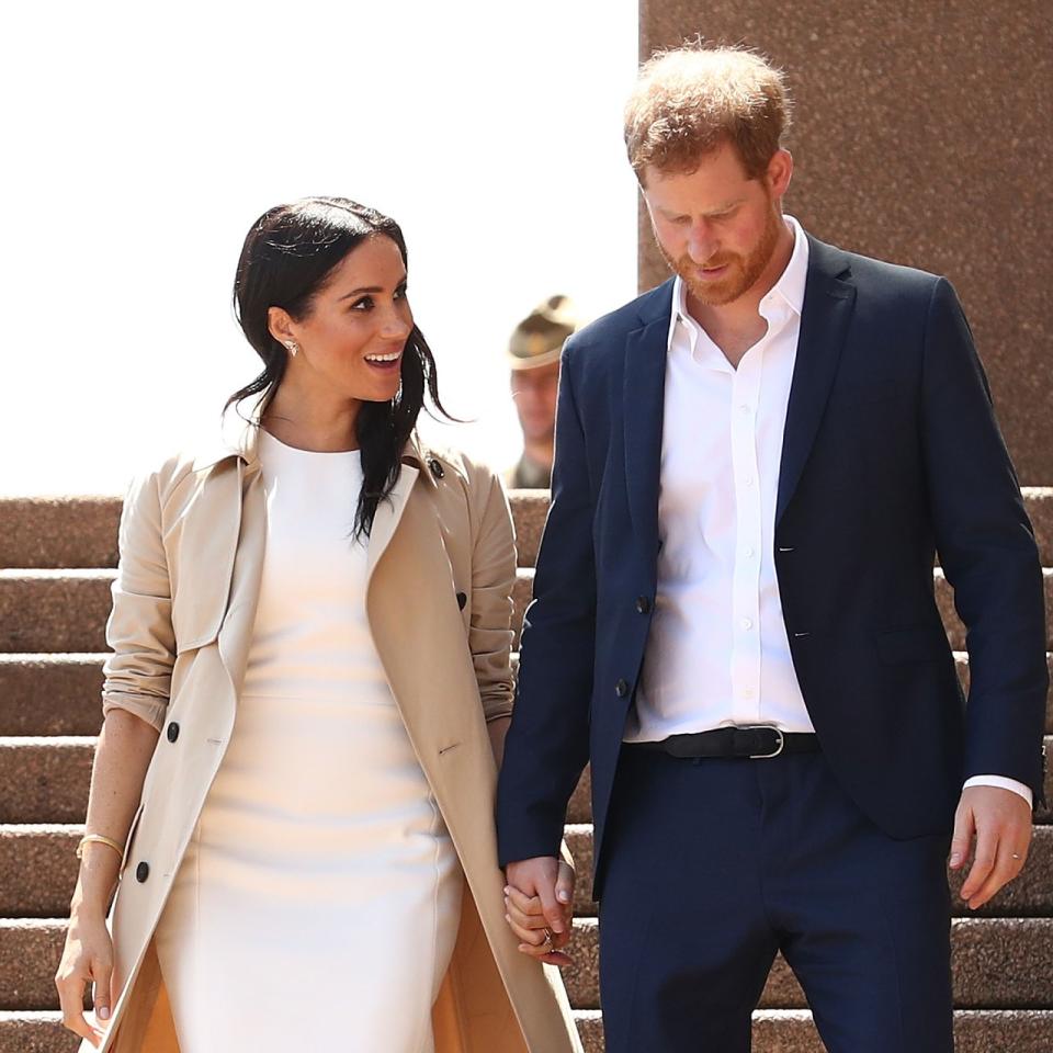 Książę Harry i Meghan Markle patrzą na siebie z miłością, schodząc po schodach