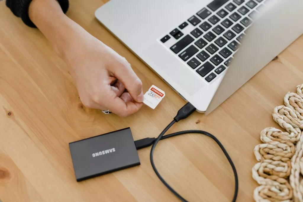 Laptop Apple z podłączonym dyskiem SSD. 