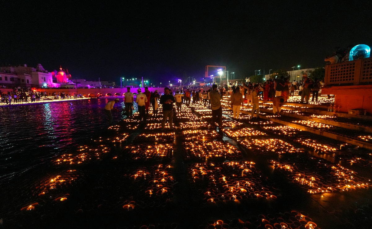 Ludzie zapalają diy podczas Depotsav w Ayodhya (PTI)