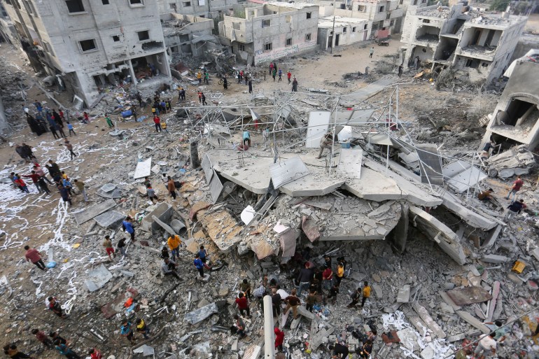 Palestyńczycy szukają ofiar podczas inspekcji miejsca izraelskiego ataku na dom należący do rodziny Fojo w Rafah