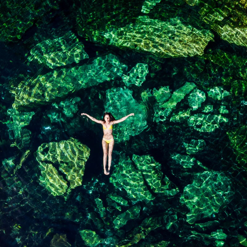 ujęcie z góry przedstawiające kobietę pływającą w cenocie w Meksyku