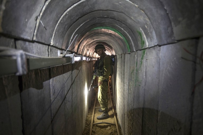 PLIK – Oficer armii izraelskiej oprowadza dziennikarzy po tunelu rzekomo używanym przez bojowników palestyńskich do ataków transgranicznych na granicy Izrael-Gaza w dniu 25 lipca 2014 r. Rozległy labirynt tuneli zbudowanych przez Hamas rozciąga się przez gęste dzielnice Izraela Strefa Gazy, ukrywająca bojowników, ich arsenał rakietowy i ponad 200 zakładników, których obecnie przetrzymują po bezprecedensowym ataku na Izrael z 7 października 2023 roku.  (AP Photo/Jack Guez, Basen, Plik)