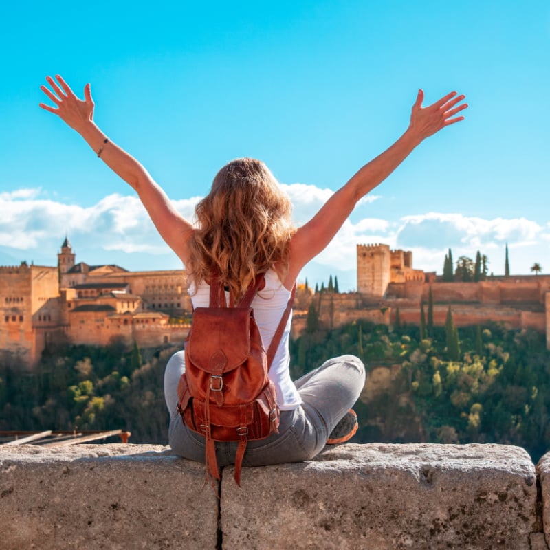 szczęśliwa turystka patrząca na Alhambrę w Granadzie w Hiszpanii