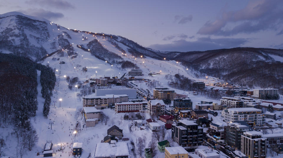 NISEKO, JAPONIA - 22 GRUDNIA 2017: Widok z lotu ptaka o zmierzchu nocnej jazdy na nartach w wiosce Niseko.  Niseko to popularne miejsce wśród ośrodków narciarskich w Japonii