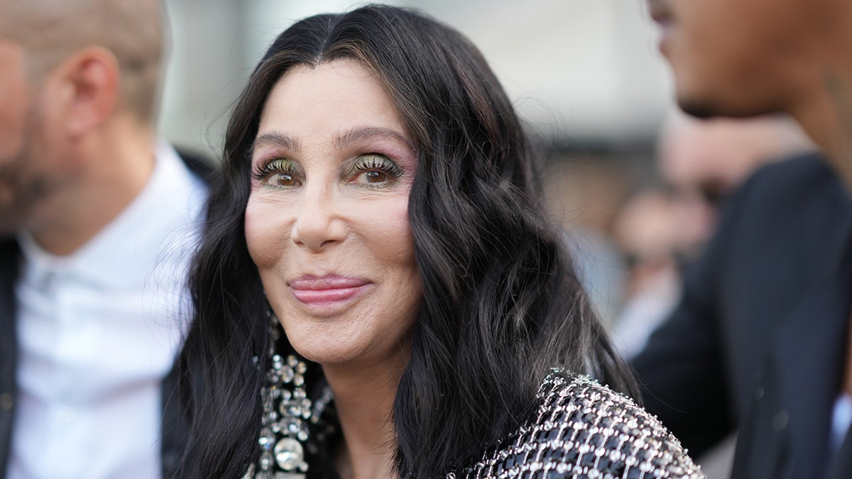 Cher uśmiecha się delikatnie w kraciastym płaszczu w Paryżu we Francji