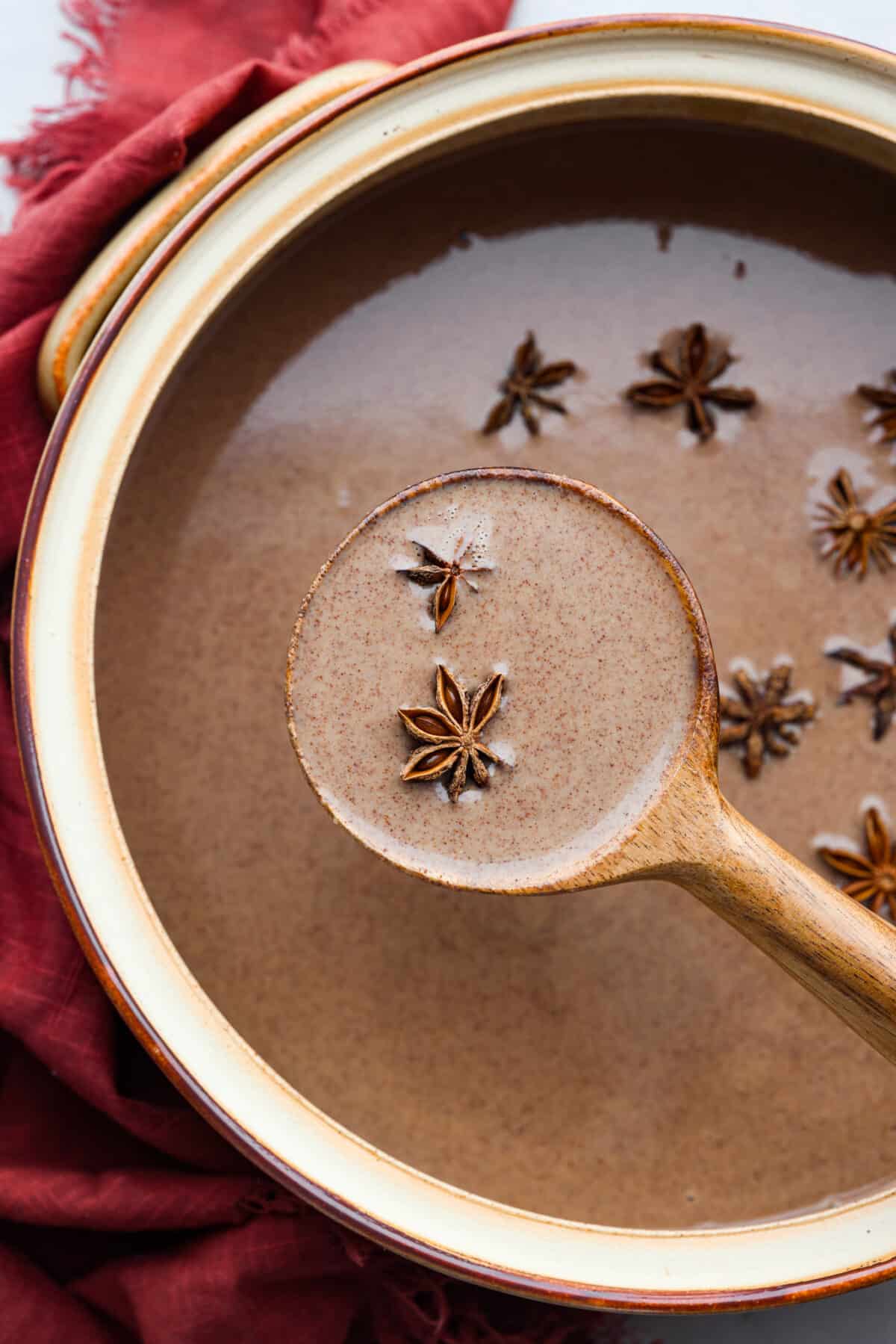 Garnek champurrado podawany z drewnianą chochlą.