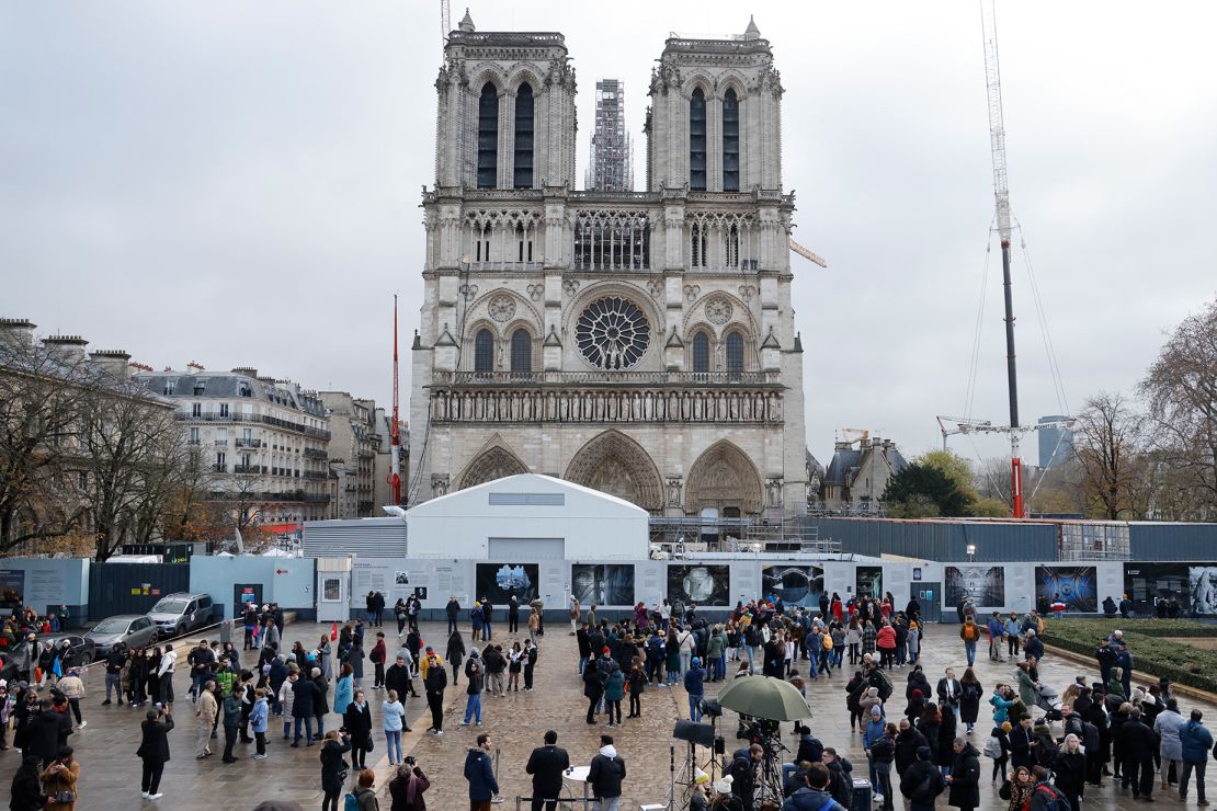 Ludzie stoją przed katedrą Notre-Dame de Paris podczas prac odbudowy Ile de la Cite w Paryżu, 8 grudnia 2023 r., rok przed tym, jak katedra, która została zniszczona przez pożar w 2019 r., zostanie otworzyć na nowo.  (Zdjęcie: Ludovic MARIN / AFP) (Zdjęcie: LUDOVIC MARIN/AFP za pośrednictwem Getty Images)