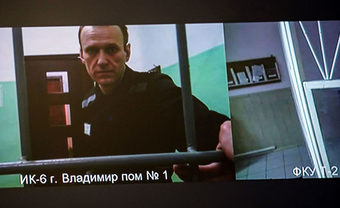 Na ekranie widać uwięzionego krytyka Kremla Aleksieja Nawalnego, który przybywa, aby wysłuchać rozprawy w sprawie apelacji złożonej od decyzji sądu o skazaniu go na 19 lat więzienia o zaostrzonym rygorze na podstawie zarzutów związanych z ekstremizmem, przed sądem w Moskwie 26 września. 2023. Nawalny był najgłośniejszym głosem opozycji w Rosji przez ostatnią dekadę i pobudzał ogromne wiece antyrządowe, zanim w 2021 r. został skazany na karę więzienia pod zarzutem oszustwa, które zdaniem jego sojuszników w kraju i za granicą było karalne.  (Zdjęcie: TATYANA MAKEYEVA / AFP) (Zdjęcie: TATYANA MAKEYEVA/AFP za pośrednictwem Getty Images)
