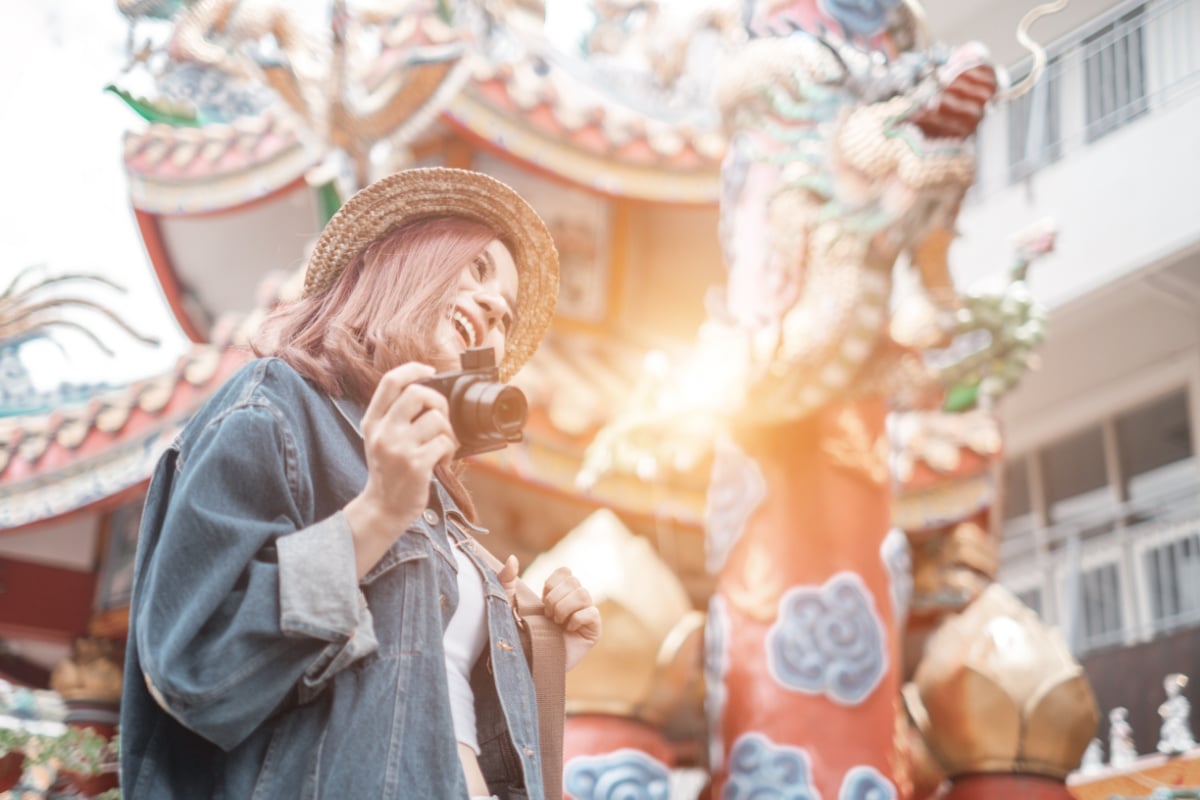 szczęśliwa kobieta podróżująca z aparatem w chiang mai w tajlandii