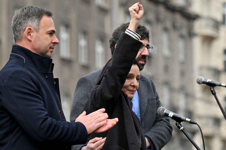 Liderka serbskiej opozycji Marinika Tepic (w środku), która przez 13 dni prowadziła strajk głodowy, pojawia się na scenie w towarzystwie swoich kolegów z opozycji Miroslava Aleksica (po lewej) i Radomira Lazovica (po prawej), gdy kilka tysięcy ludzi uczestniczy w wiecu opozycji [Andrej ISAKOVIC / AFP]