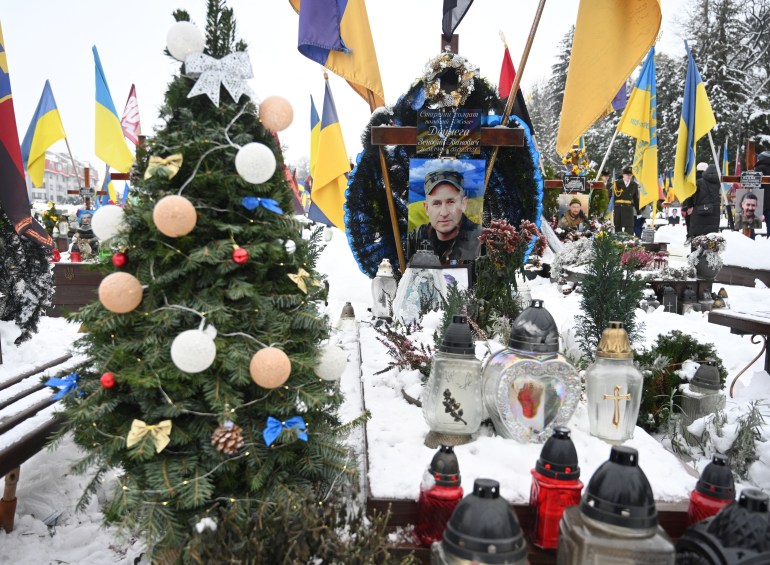 To zdjęcie wykonane 6 grudnia 2023 r. przedstawia choinkę obok grobu ukraińskiego żołnierza na cmentarzu Łyczakowskim, w Dzień Sił Zbrojnych Ukrainy we Lwowie na zachodzie Ukrainy, podczas rosyjskiej inwazji na Ukrainę.  (Zdjęcie: JURIY DYACHYSHYN / AFP)