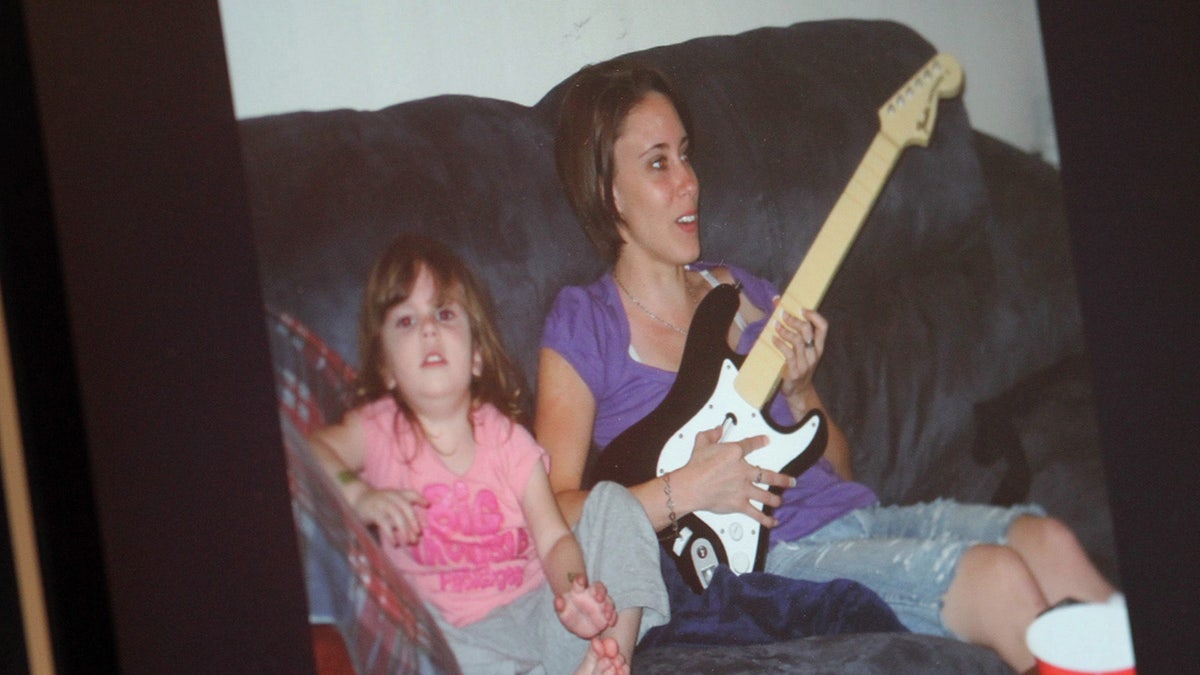 Caylee Anthony siedzi obok swojej matki Casey Anthony i gra na gitarze