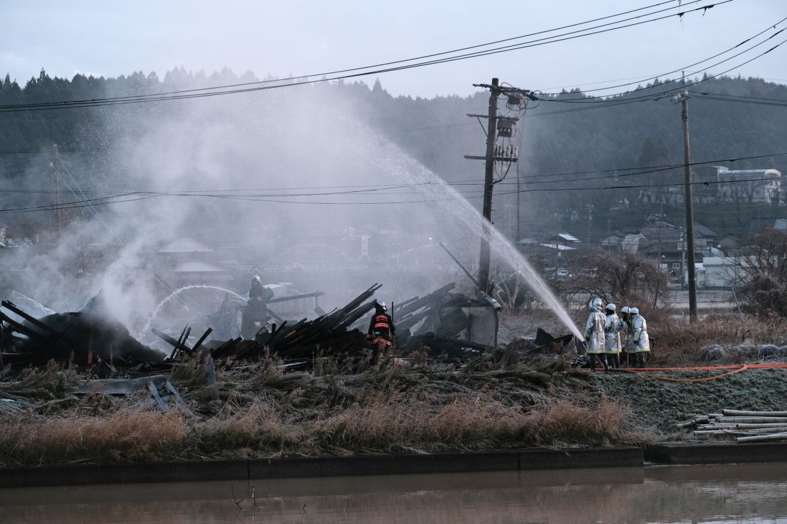 Strażacy gaszą pożar w Nanao w prefekturze Ishikawa w Japonii wczesnym rankiem we wtorek, 2 stycznia 2024 r. Co najmniej sześć osób zginęło, a inne zostały ranne w wyniku potężnego trzęsienia ziemi, które nawiedziło półwysep Noto na północno-zachodnim wybrzeżu Japonii, niszcząc budynki, wyboczając dróg i wywoływanie pożarów.  Fotograf: Soichiro Koriyama/Bloomberg za pośrednictwem Getty Images