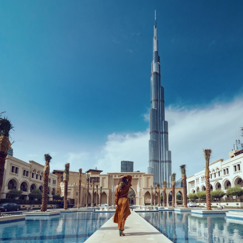 kobieta stojąca przed widokiem na Burj Khalifa w Dubaju, Zjednoczone Emiraty Arabskie