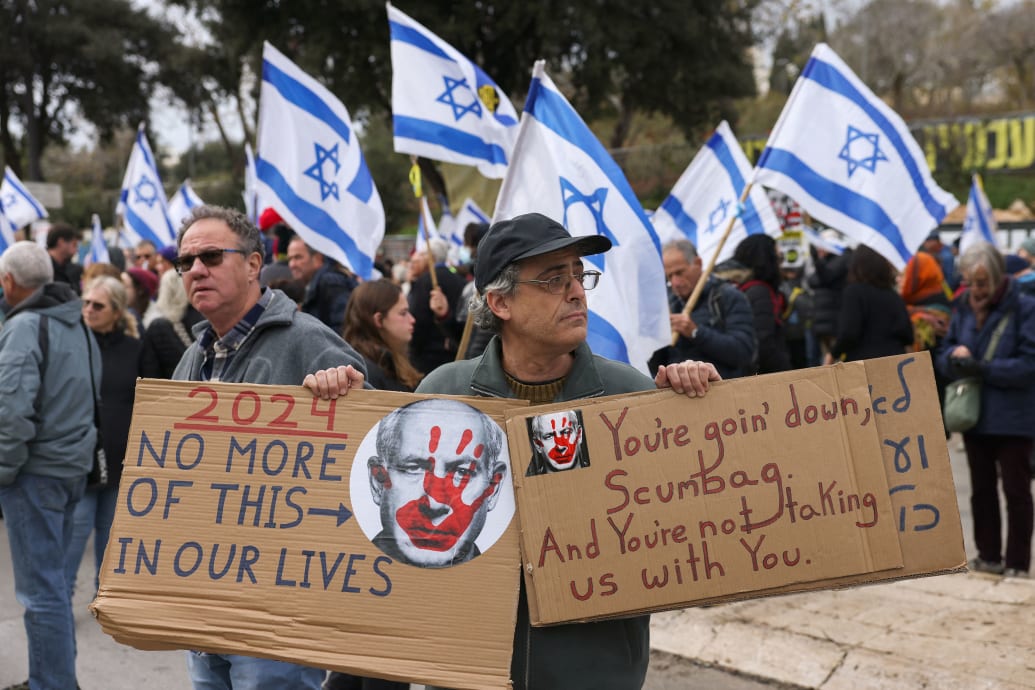 Protestujący podnosi plakaty przeciwko izraelskiemu premierowi Benjaminowi Natanyahu podczas wiecu żądającego uwolnienia Izraelczyków wziętych jako zakładników sto dni wcześniej przez palestyński ruch Hamas, 7 października