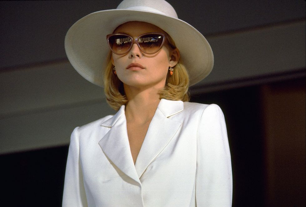 kobieta ubrana w biały kapelusz i okulary przeciwsłoneczne