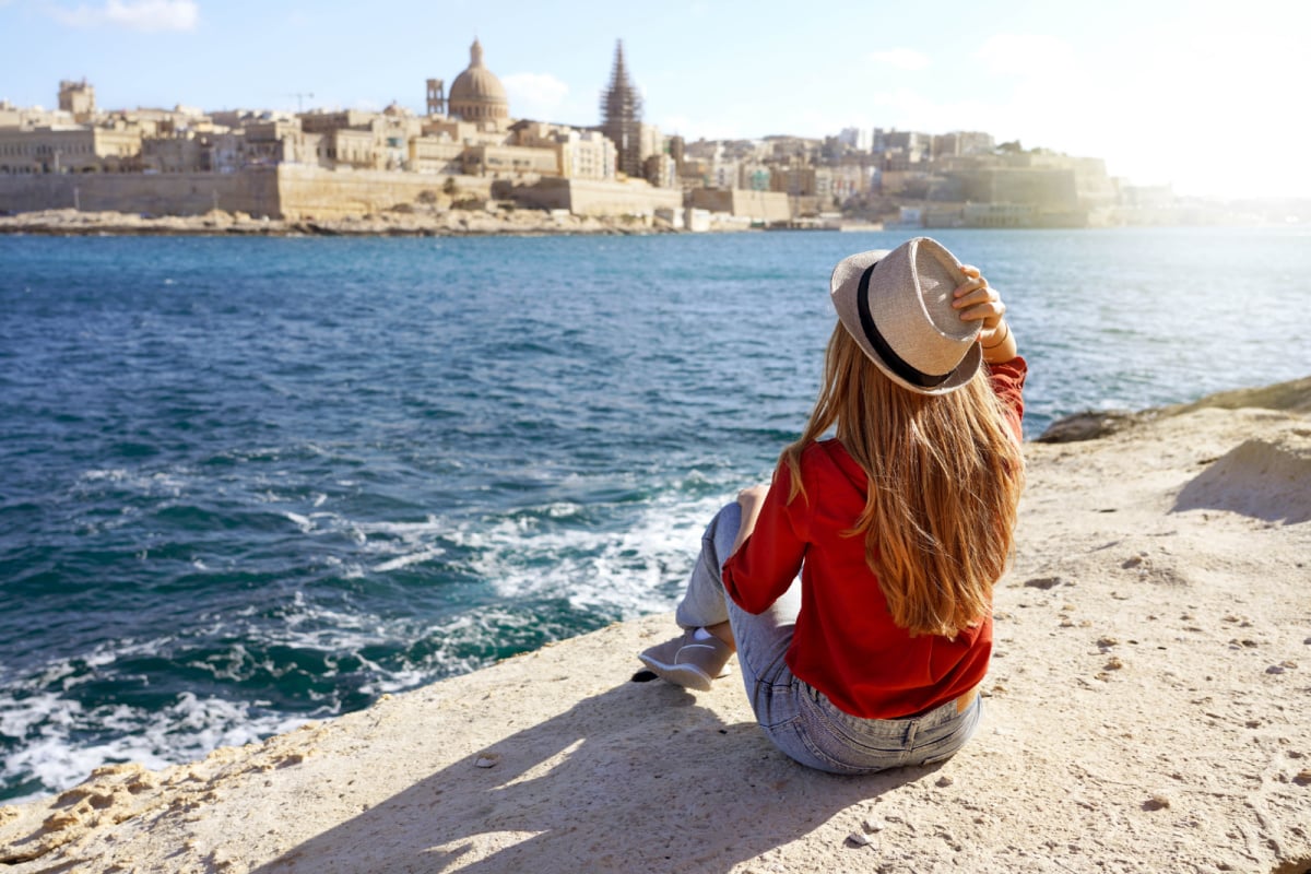 młoda podróżniczka spogląda nad wodę na miasto Valletta na Malcie