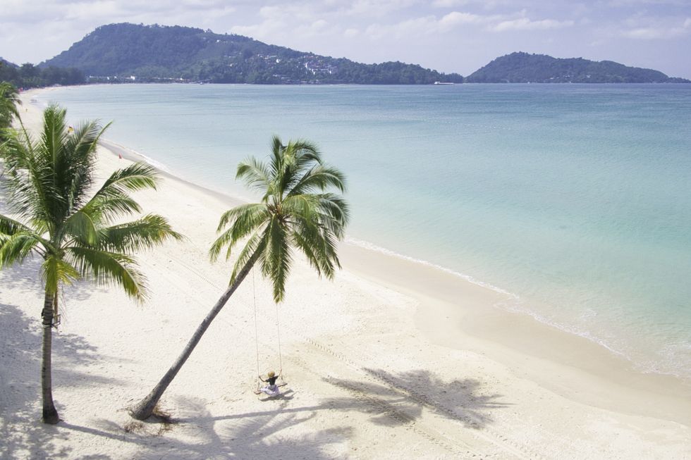 podróżujący samotnie baw się na huśtawce kokosowej na plaży Patong Plaża Patong, która jest 3-kilometrowym pasem złotego piasku, jest jedną z najpopularniejszych plaż w Phuket w Tajlandii