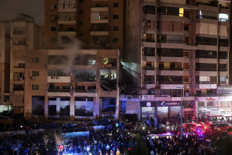 Ludzie gromadzą się w pobliżu uszkodzonego miejsca po eksplozji