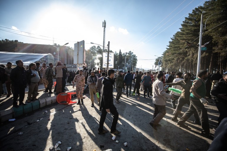 Ludzie rozchodzą się w pobliżu miejsca, w którym dwie eksplozje w krótkich odstępach czasu uderzyły w tłum z okazji rocznicy zabójstwa generała Gwardii Qasema Soleimaniego w 2020 r., w pobliżu meczetu Saheb al-Zaman w mieście Kerman w południowym Iranie