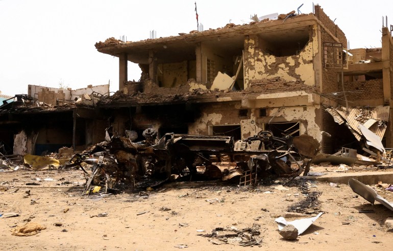 ZDJĘCIE PLIKU: Uszkodzony samochód i budynki są widoczne na rynku centralnym podczas starć pomiędzy paramilitarnymi Siłami Szybkiego Wsparcia a armią w Północnym Chartumie w Sudanie.  27 kwietnia 2023. REUTERS/ Mohamed Nureldin Abdallah/File Photo