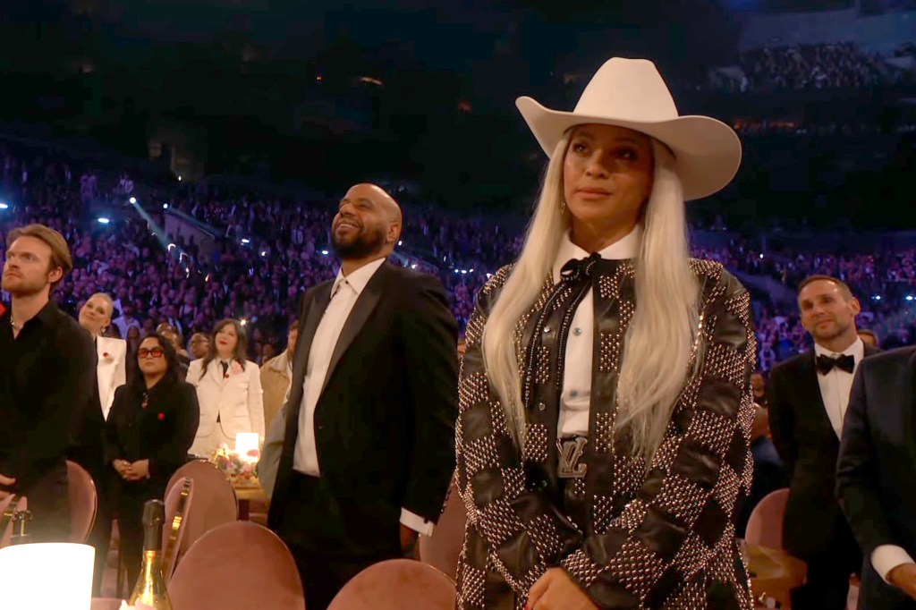 Beyonce obserwuje, jak Jay-Z przemawia na scenie.