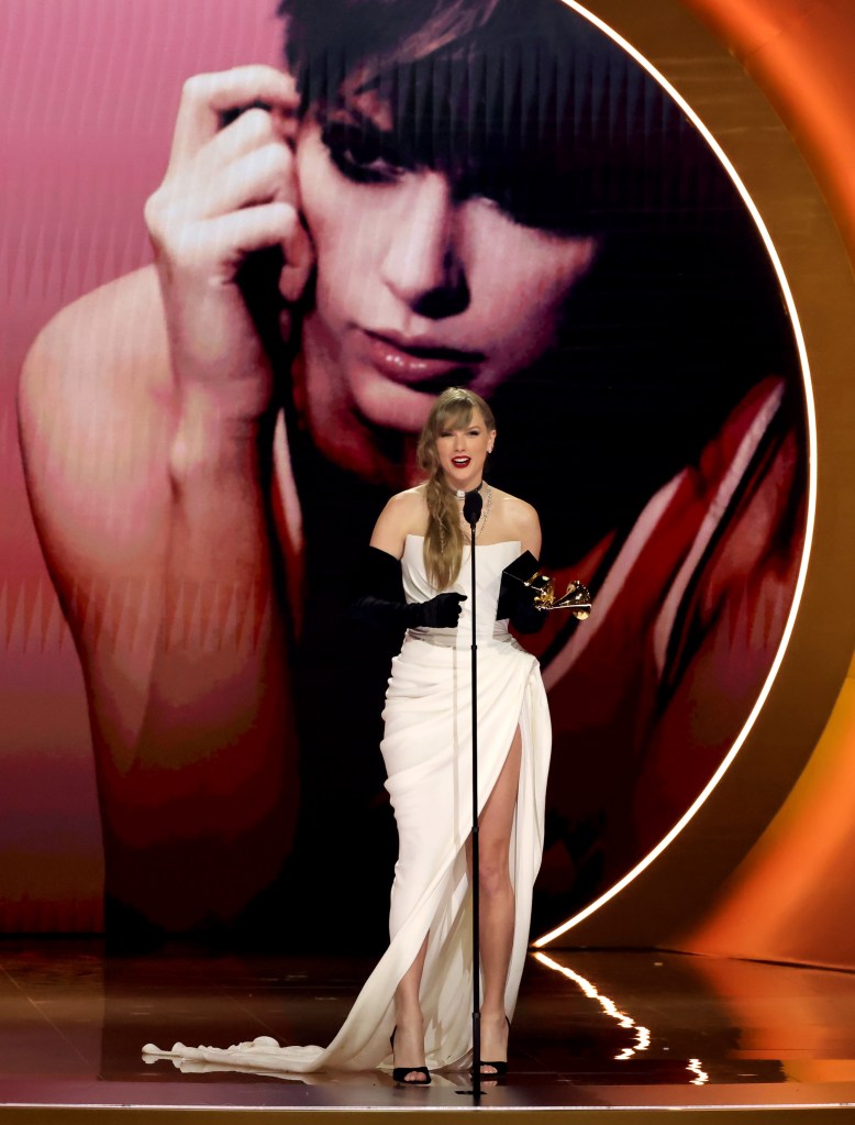 Taylor Swift odbiera nagrodę dla najlepszego popowego albumu wokalnego w białej sukni podczas 66. ceremonii rozdania nagród Grammy.