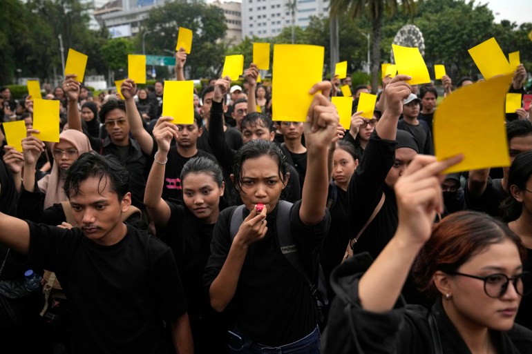 Protestujący po wyborach pokazali „żółtą kartkę” dla Jokowi.  Wszyscy są ubrani na czarno.