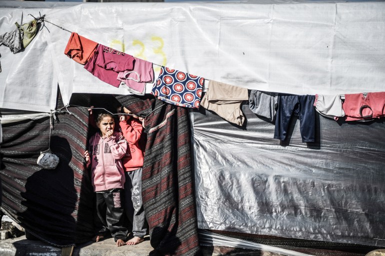 Wysiedlone dzieci palestyńskie stoją w namiocie w Rafah w południowej Gazie