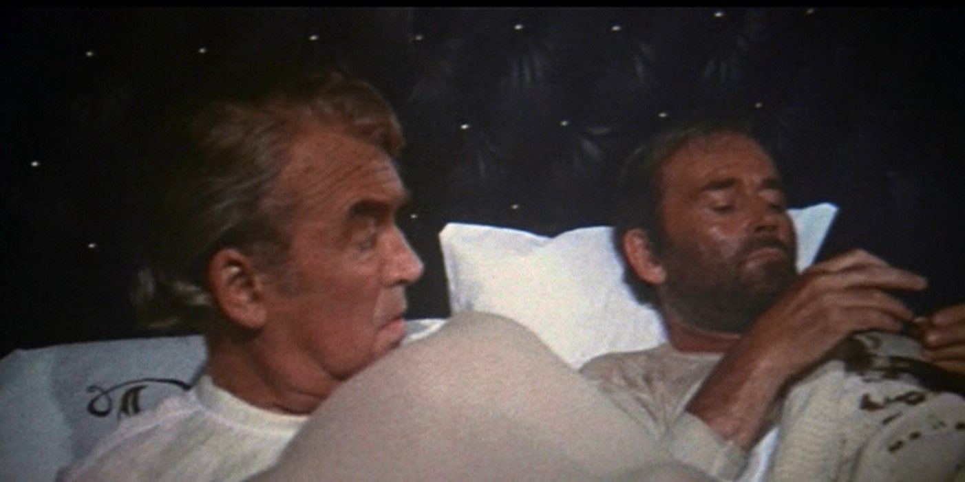 James Stewart jako John O'Hanlan i Henry Fonda jako Harley Sullivan leżący w łóżku w The Cheyenne Social Club