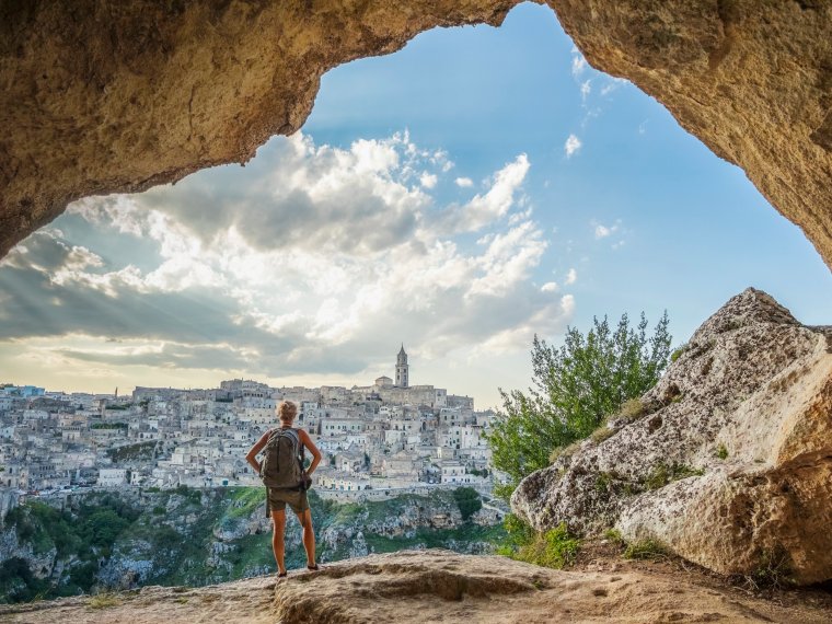 turystka patrzy na miasto Matera z jaskini na wzgórzu