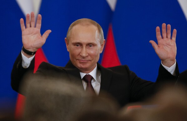 PLIK – Prezydent Rosji Władimir Putin gestykuluje po podpisaniu traktatu włączającego Krym jako część Rosji na Kremlu w Moskwie, Rosja, we wtorek, 18 marca 2014 r. Szybkie i bezkrwawe zajęcie przez Putina ukraińskiego Półwyspu Krymskiego, siedziby rosyjskiej floty czarnomorskiej i popularnym miejscem wakacyjnym, wywołał falę patriotyzmu i spowodował gwałtowny wzrost jego popularności. "Krym jest nasz!" stało się popularnym hasłem w Rosji.  (AP Photo/Alexander Zemlianichenko, plik)