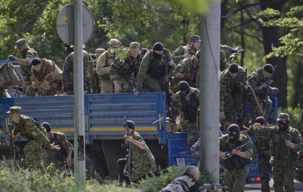 PLIK – Prorosyjscy bandyci zajmują pozycje w pobliżu lotniska pod Donieckiem na Ukrainie w poniedziałek, 26 maja 2014 r. Kilka tygodni po aneksji przez Rosję Krymu Ukrainy 18 marca 2014 r. wspierani przez Moskwę separatyści rozpoczęli powstanie we wschodniej Ukrainie, walcząc z siłami Kijowa .  Kreml zaprzeczył wspieraniu rebelii żołnierzami i bronią, pomimo licznych dowodów temu zaprzeczających.  (AP Photo/Vadim Ghirda, plik)