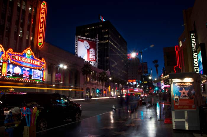 Hollywoodzka ulica nocą z migającymi znakami i ludźmi