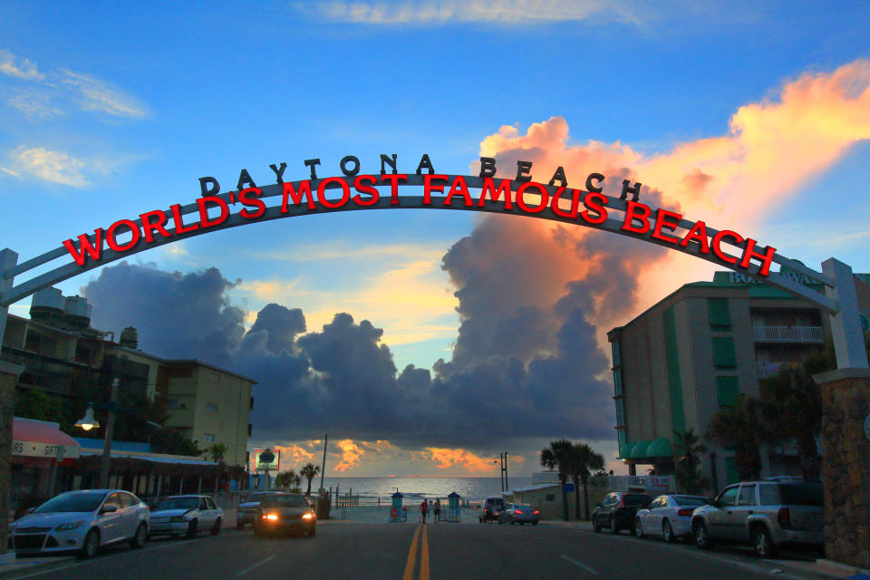 Zachód słońca na plaży Daytona ze słynnym odczytem z łuku "NAJSŁYNNIEJSZA PLAŻA ŚWIATA" nad ulicą prowadzącą do oceanu