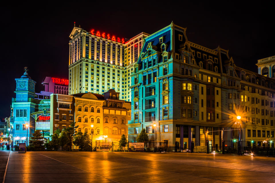Nocny widok na budynki Caesar's i Trump Plaza z podświetlanymi oznakowaniami