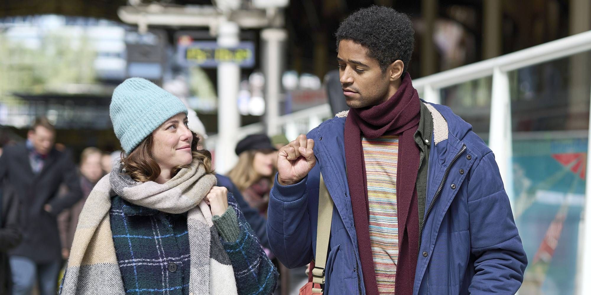 Kaya Scodelario i Alfred Enoch w filmie „To są Boże Narodzenie” uśmiechają się, patrząc na siebie.