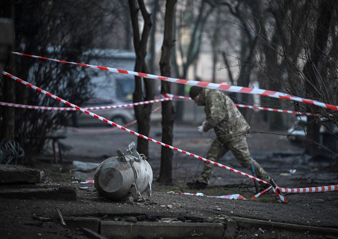 Członek oddziału bombowego pracuje obok części rakiety.