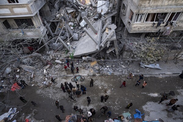Palestyńczycy sprawdzają zniszczenia budynków mieszkalnych po izraelskim nalocie w Rafah w południowej Strefie Gazy, niedziela, 24 marca 2024 r. (AP Photo/Fatima Shbair)