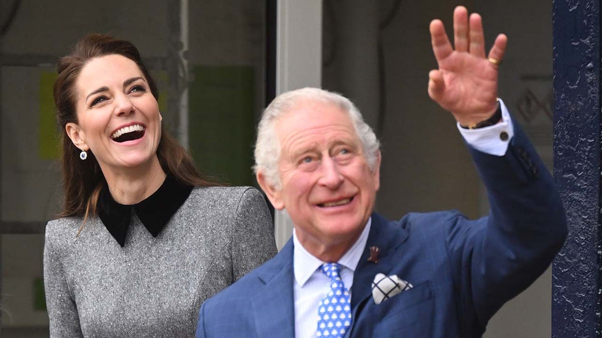 Kate Middleton ma na sobie szary garnitur obok króla Karola w niebieskim garniturze.