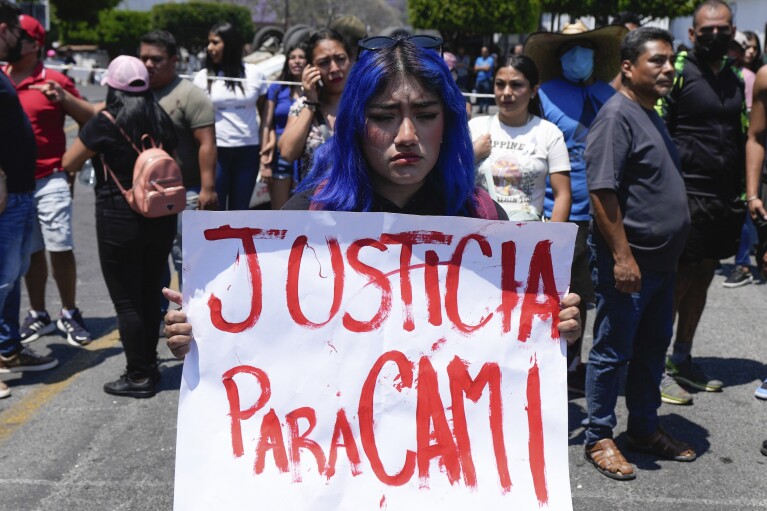 Kobieta trzyma tabliczkę z wiadomością po hiszpańsku: "Sprawiedliwość dla Cami" w nawiązaniu do 8-letniej dziewczynki, która zaginęła poprzedniego dnia w Taxco w Meksyku, w czwartek, 28 marca 2024 r. 8-letnia dziewczynka zaginęła w środę;  jej ciało znaleziono w czwartek wczesnym rankiem na drodze na obrzeżach miasta.  (AP Photo/Fernando Llano)