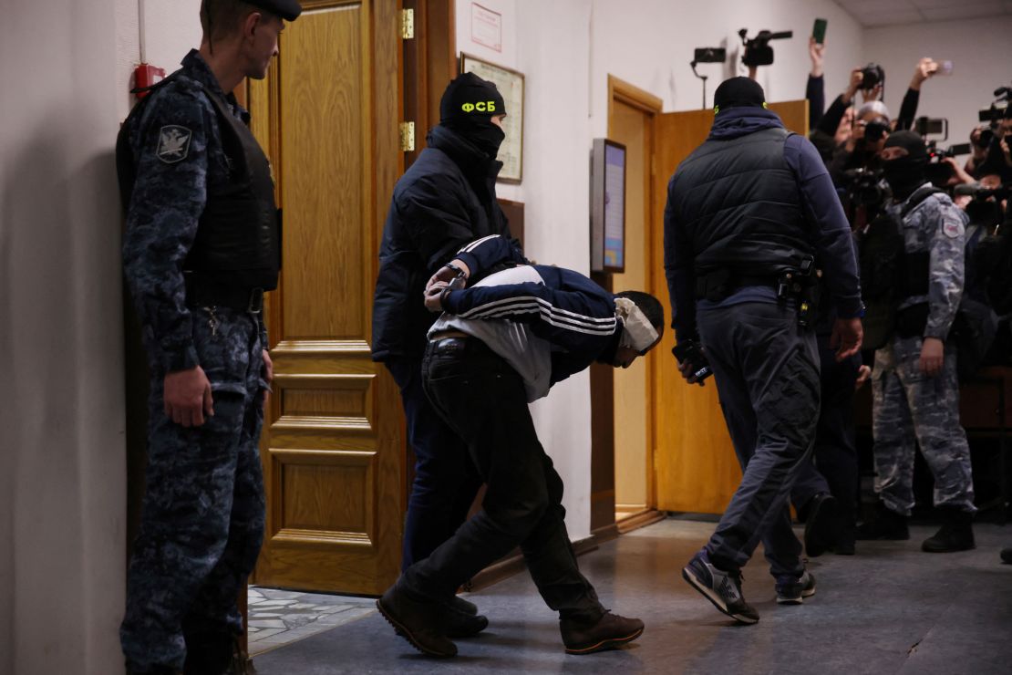 Mężczyzna podejrzany o udział w ataku jest eskortowany przez rosyjskich funkcjonariuszy organów ścigania przed rozprawą w sprawie tymczasowego aresztowania przed Sądem Rejonowym Basmanny w Moskwie w dniu 24 marca 2024 r.