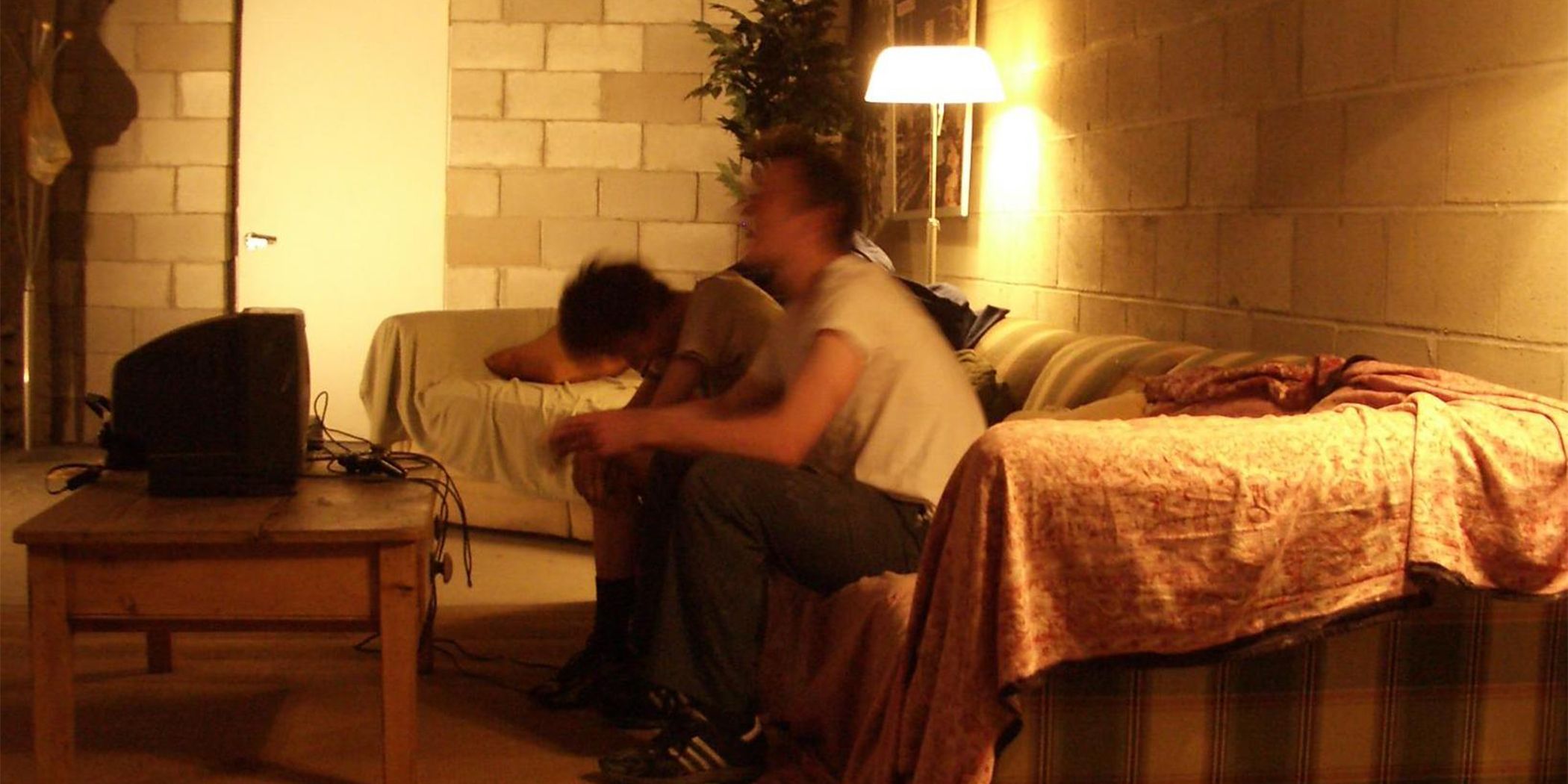 Zdjęcie dwóch rozmazanych w ruchu facetów siedzących na kanapie przed telewizorem