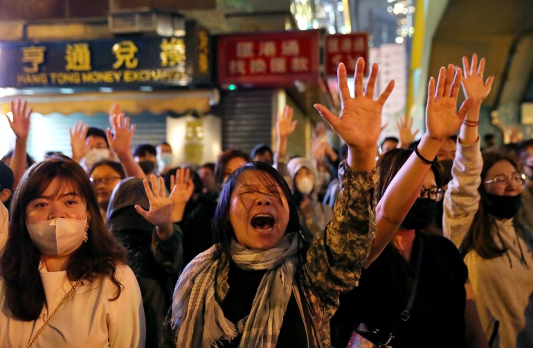 Protestujący śpiewają „Chwała Hongkongowi” przed Politechniką (PolyU), podczas gdy policja oblega go w Hongkongu w Chinach