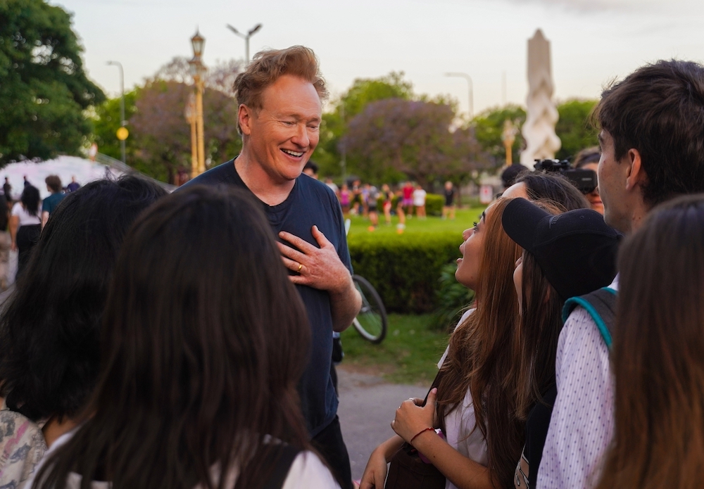Conan O'Brien rozmawia z grupą ludzi w serialu podróżniczym „Conan O'Brien Must Go” o Maxie