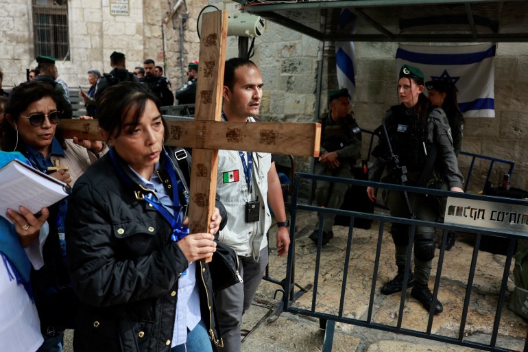 Wierni niosą krzyż podczas procesji w Wielki Piątek na Via Dolorosa na Starym Mieście w Jerozolimie